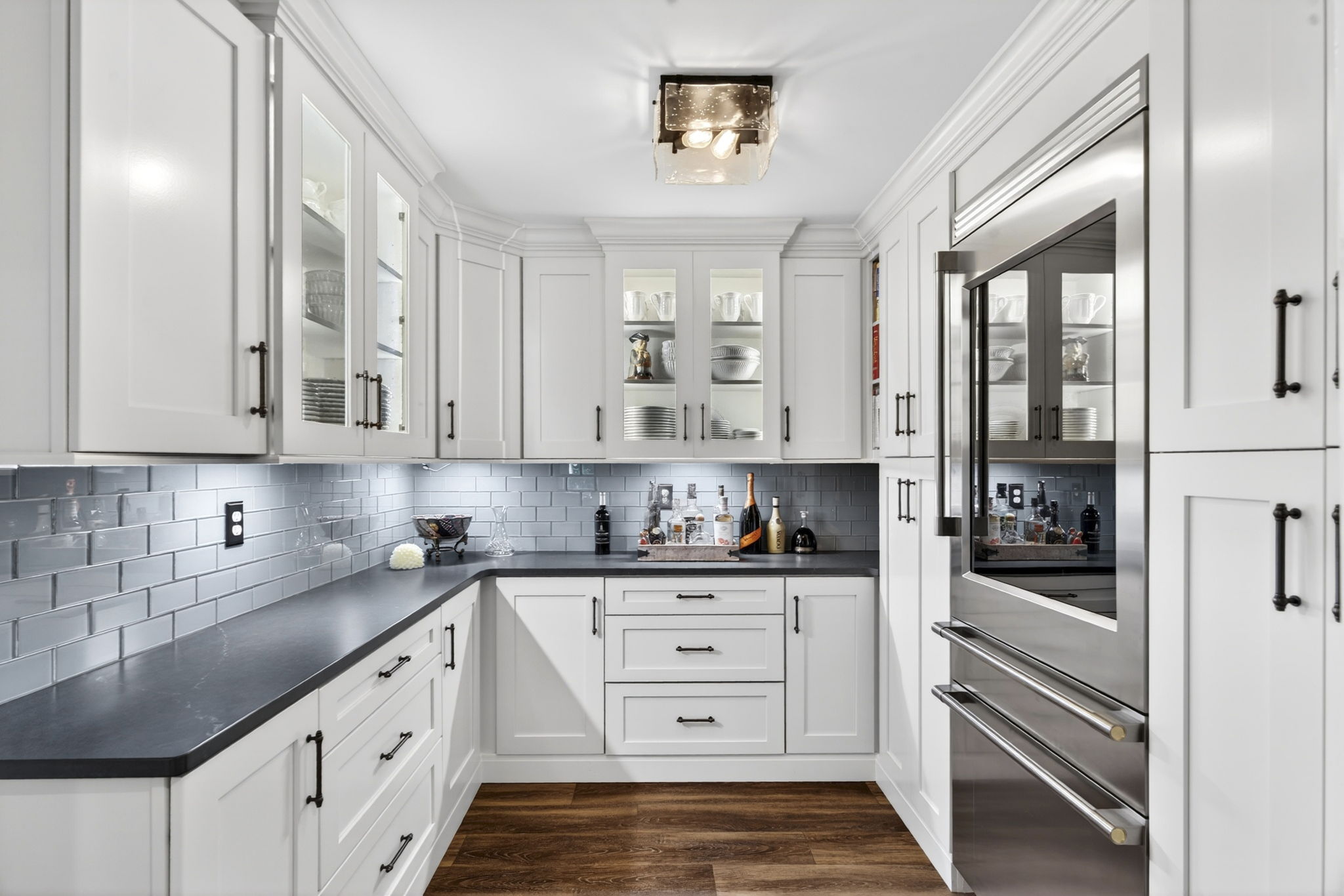 Butler's pantry detail with glass-front cabinetry and slate counters