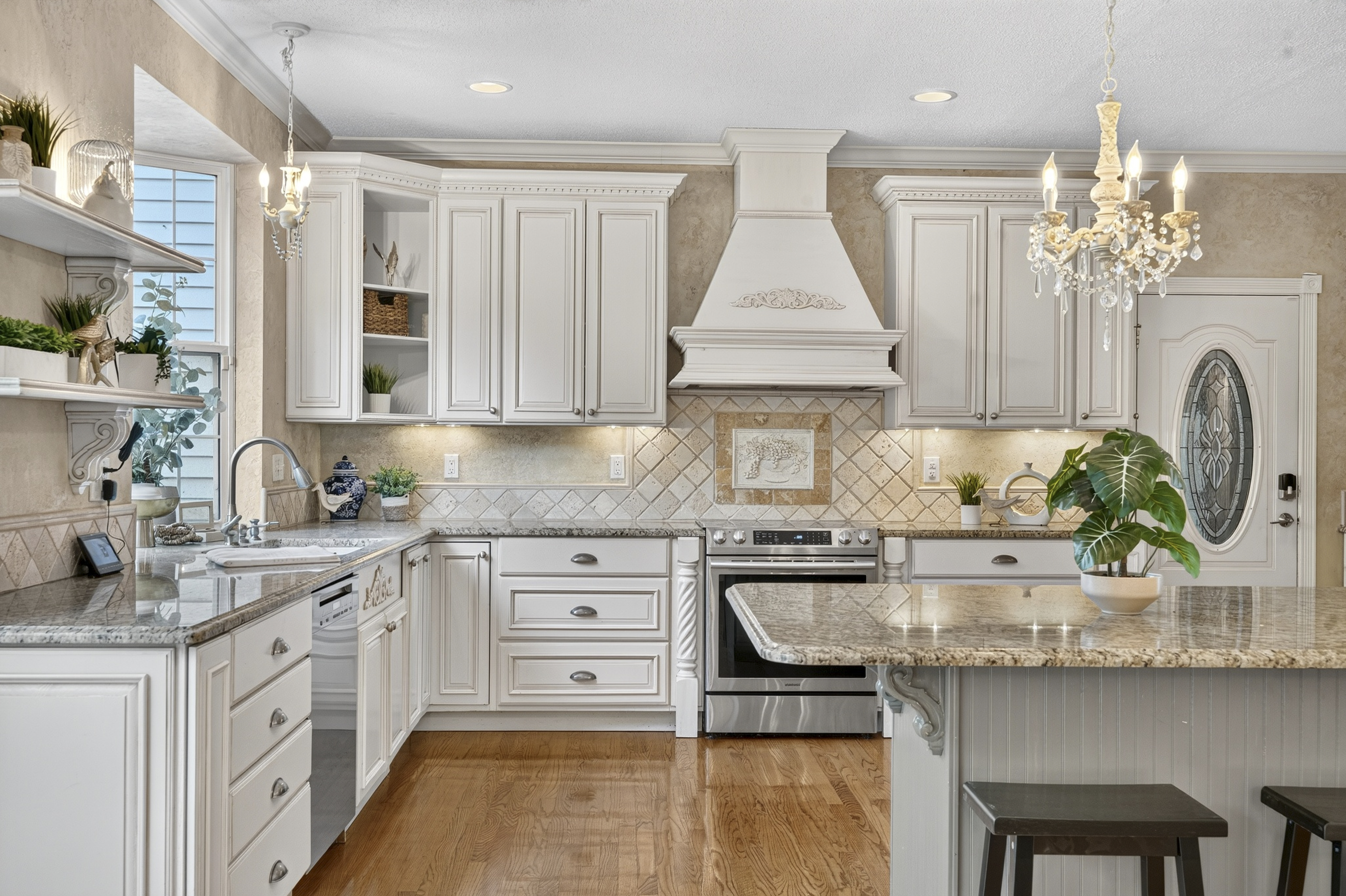 Bright traditional kitchen with chandelier and granite island